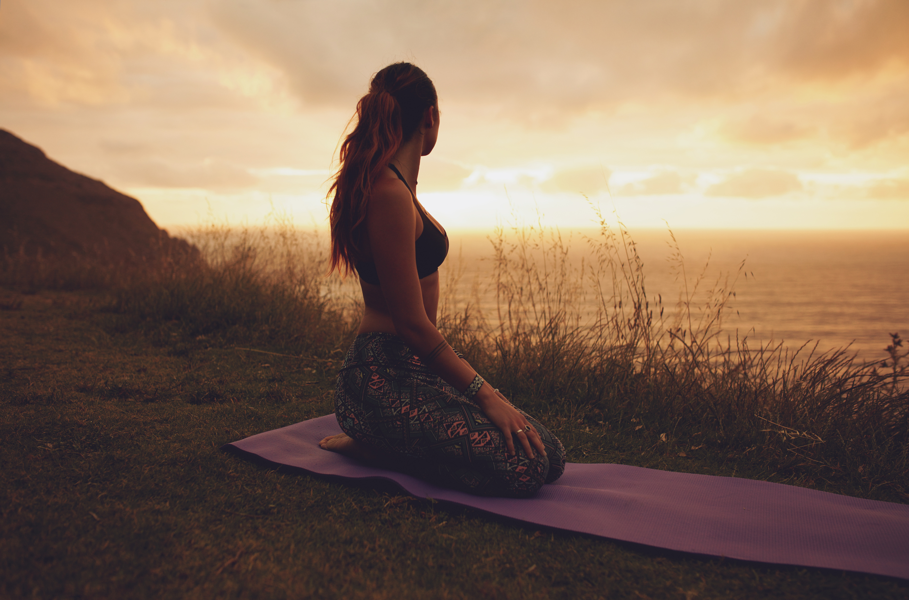 Fitness Woman in Vajrasana Pose at Sunset